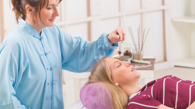 Alternative Medicine Therapist Using Pendulum To Make A Diagnosis