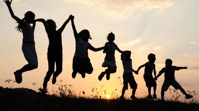 Silhouette, Group Of Happy Children Playing On Meadow, Sunset, Summertime