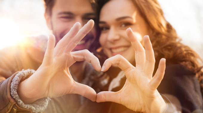Closeup Of Couple Making Heart Shape With Hands