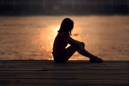 60343150 - Sad Woman Silhouette Worried At Sunset