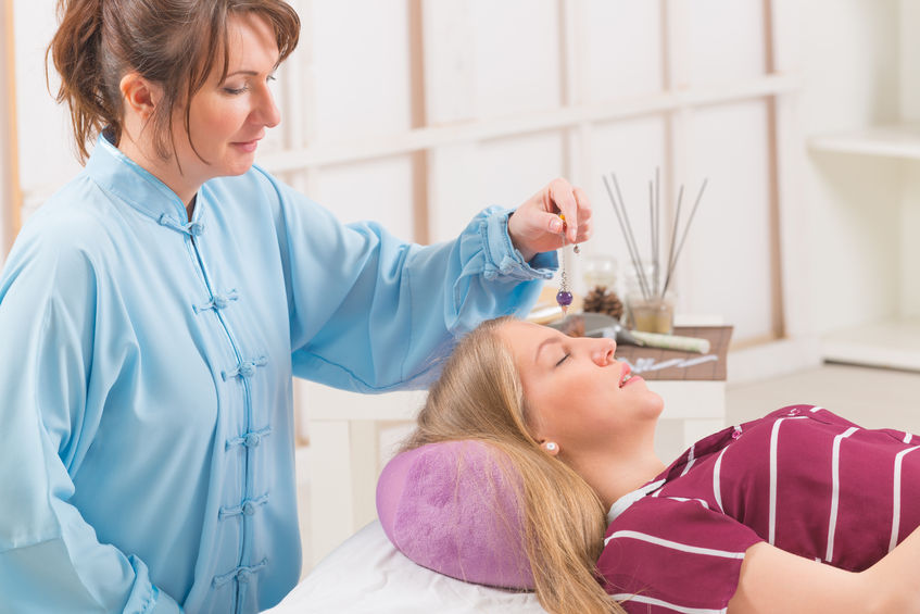 Alternative Medicine Therapist Using Pendulum To Make A Diagnosis